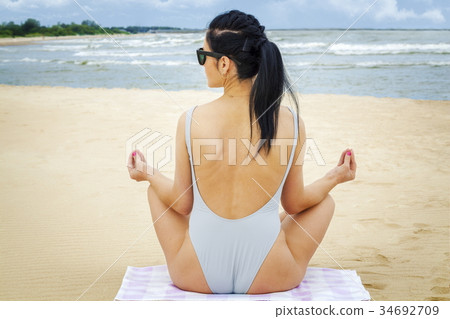 Woman meditates by the sea 34692709