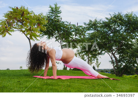 Pregnant woman is practicing yoga 34693397