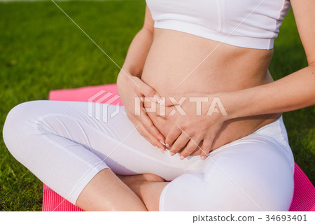 Pregnant woman with hands over tummy. Pregnant woman with hands over tummy. 34693401
