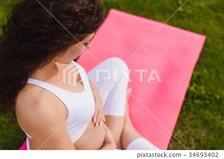 Pregnant woman with hands over tummy. 34693402