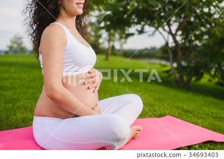 Pregnant woman with hands over tummy. Pregnant woman with hands over tummy. 34693403