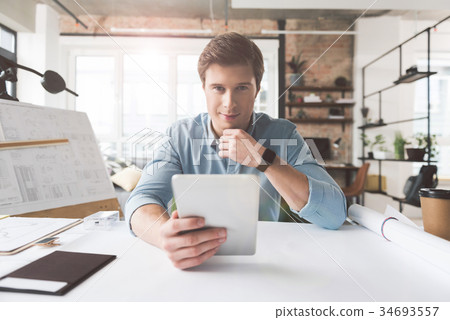Positive skillful architect is laboring in office Positive skillful architect is laboring in office 34693557
