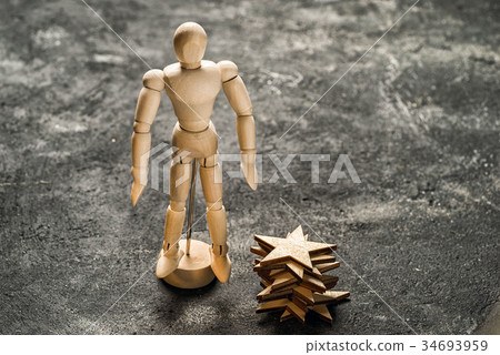 Wooden dummy stands near the stack of wooden stars Wooden dummy stands near the stack of wooden stars 34693959