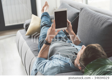 Man watching at electronic tablet Man watching at electronic tablet 34694029