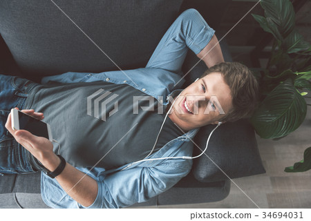 Happy man listening music at home Happy man listening music at home 34694031