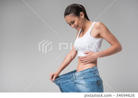 Cheerful young woman is satisfied with her diet Cheerful young woman is satisfied with her diet 34694626