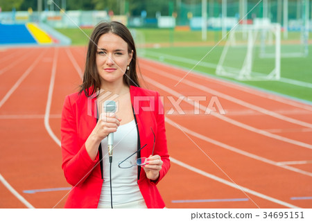 Young girl TV reporter is broadcasting Young girl TV reporter is broadcasting 34695151