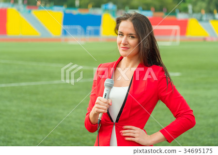 Young girl TV reporter is broadcasting Young girl TV reporter is broadcasting 34695175