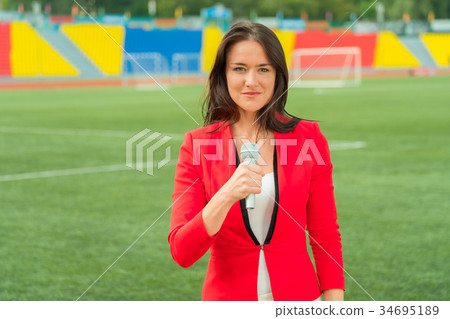 Young girl TV reporter is broadcasting Young girl TV reporter is broadcasting 34695189