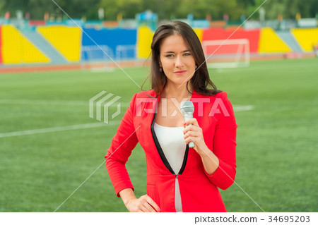Young girl TV reporter is broadcasting Young girl TV reporter is broadcasting 34695203