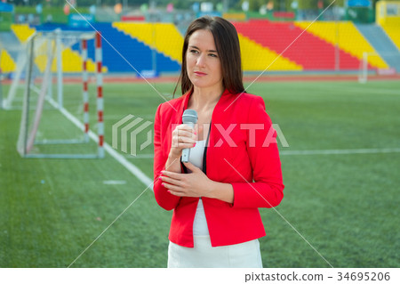 Young girl TV reporter is broadcasting Young girl TV reporter is broadcasting 34695206