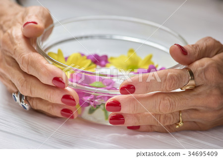 Female hands holding bowl with water. 34695409