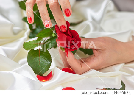 Hands with manicured nails and red rose. Hands with manicured nails and red rose. 34695624
