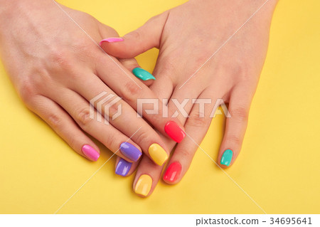 Woman nails painted in different colors. Woman nails painted in different colors. 34695641