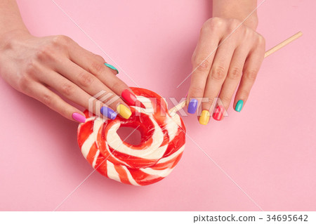 Female hands with large lollypop. 34695642