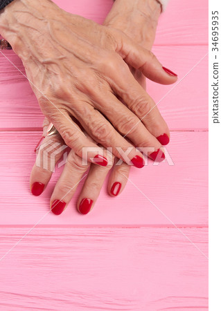 Female manicured hands on wooden background. Female manicured hands on wooden background. 34695935