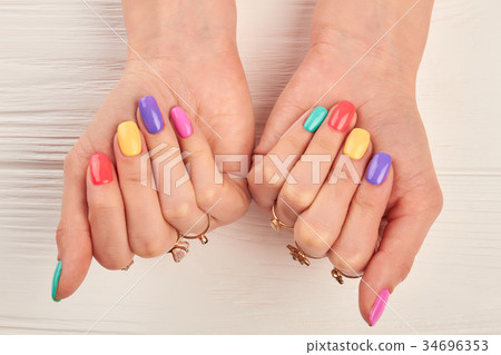 Summer fashion manicure and golden rings. 34696353