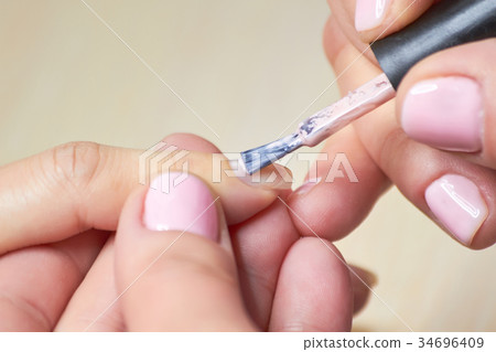 Woman receiving manicure by beautician. 34696409