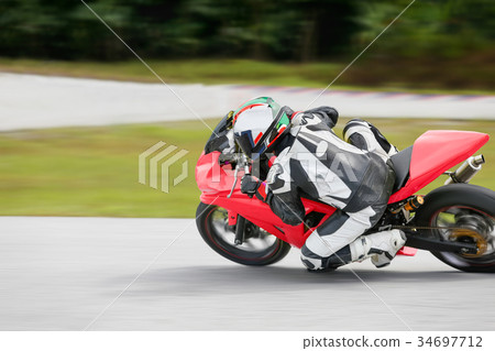 Motorcycle leaning into a fast corner on track 34697712