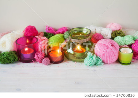 Yarn, candles, knitting on a white background wood 34700836