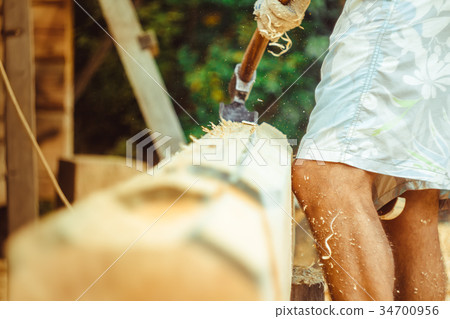 a man cuts a log 34700956