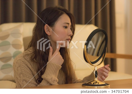 一個年輕的女人患有粗糙的皮膚 一個年輕的女人患有粗糙的皮膚 34701704