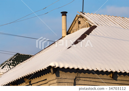 Snow on the roof of the house at sunset Snow on the roof of the house at sunset 34703112