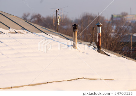 Snow on the roof of the house at sunset Snow on the roof of the house at sunset 34703135