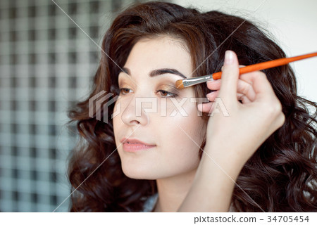 Eye makeup woman applying eyeshadow powder. Make Eye makeup woman applying eyeshadow powder. Make 34705454