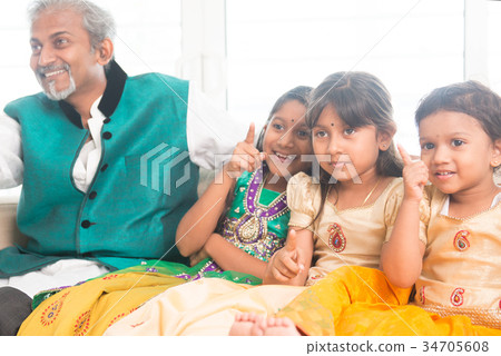 Father and daughters watching tv at home Father and daughters watching tv at home 34705608