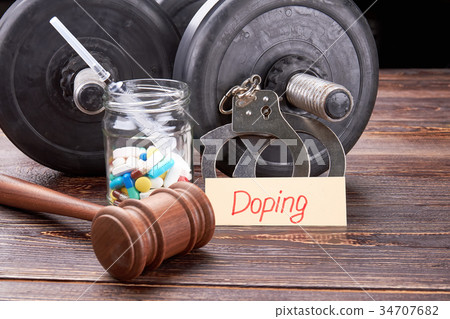 Gavel, colorful pills, syringe, dumbbells. Gavel, colorful pills, syringe, dumbbells. 34707682