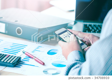 Businessman hand looking data result at smartphone Businessman hand looking data result at smartphone 34708910