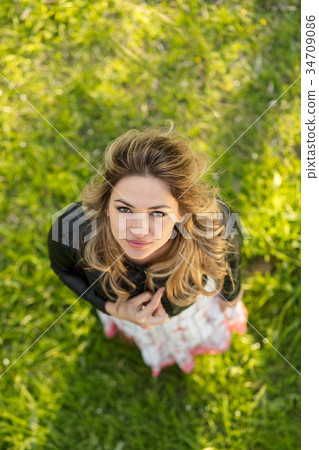 Smiling woman standing outdoors in nature, she is Smiling woman standing outdoors in nature, she is 34709086