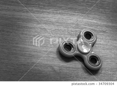 Spinner on a wooden desk Spinner on a wooden desk 34709304