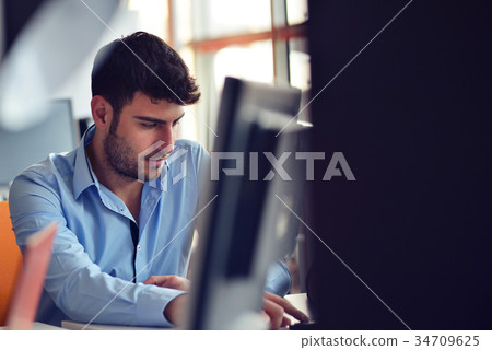 Freelance programmer working in startup office Freelance programmer working in startup office 34709625