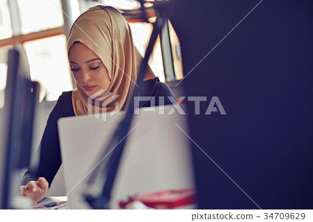 Muslim asian woman working in office with laptop 34709629