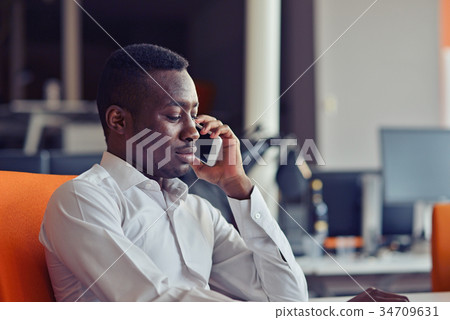 African American businessman on the phone sitting African American businessman on the phone sitting 34709631