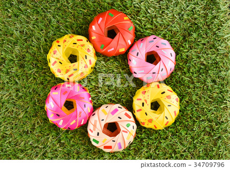 Coin folding with Ribbon is shaped colorful donut Coin folding with Ribbon is shaped colorful donut 34709796