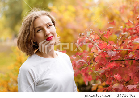Beautiful young woman in autumn park. Season and 34710462