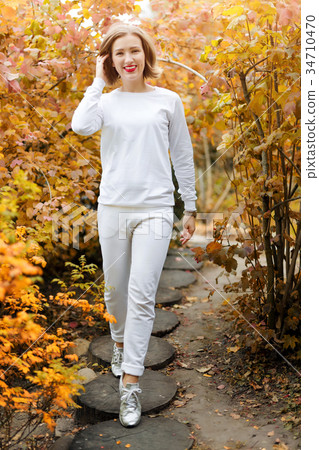 Beautiful young woman in autumn park. Season and 34710470