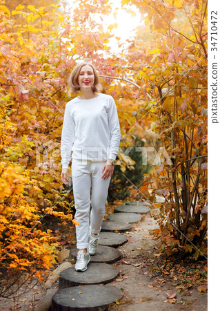 Beautiful young woman in autumn park. Season and 34710472