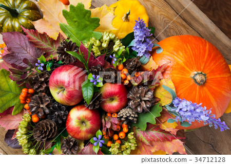 Ripe red apples, pumpkins, and blue flowers 34712128