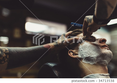 Barber shaving client 34713538