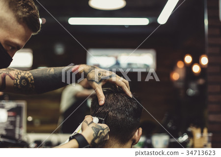 Barber shaving man in chair 34713623