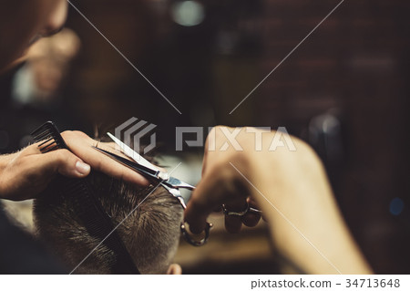 Crop barber doing haircut for client 34713648