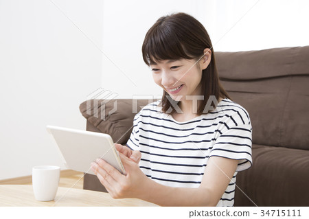 A young woman operating a tablet 34715111