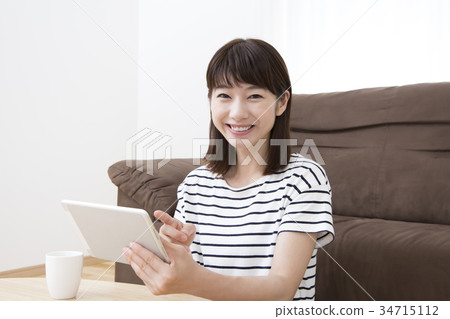 A young woman operating a tablet A young woman operating a tablet 34715112