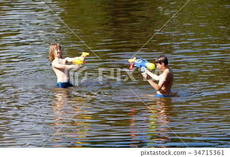 Two Boys Fighting with Squirt Guns. Two Boys Fighting with Squirt Guns. 34715361