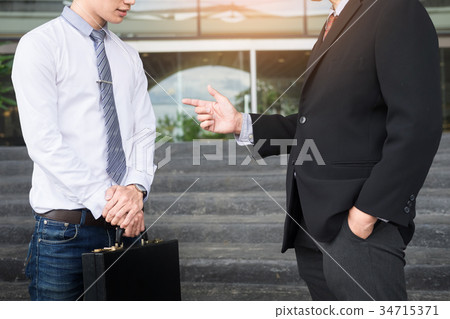 Two confident business partners discussing workflow plan talking 34715371