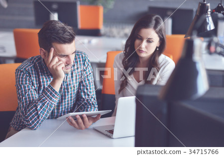 Young Casual business couple using computer in the 34715766